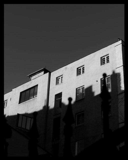 Building in Bratislava Old Town with strong shadow. Photo is black and white.
